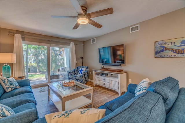 living room with light hardwood / wood-style flooring and ceiling fan