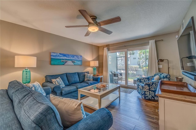 living room with hardwood / wood-style floors, ceiling fan, and a textured ceiling