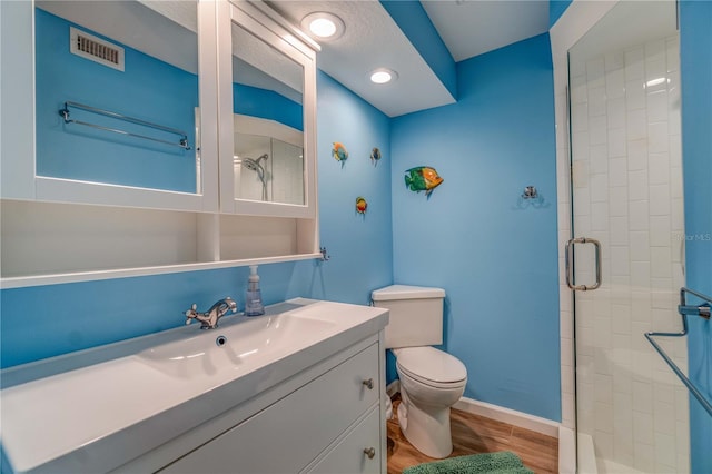 bathroom with vanity, hardwood / wood-style flooring, toilet, and walk in shower