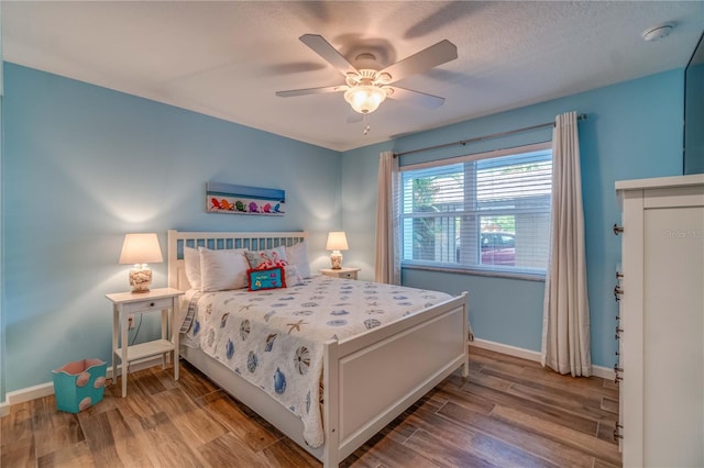 bedroom featuring ceiling fan, light hardwood / wood-style floors, and a textured ceiling