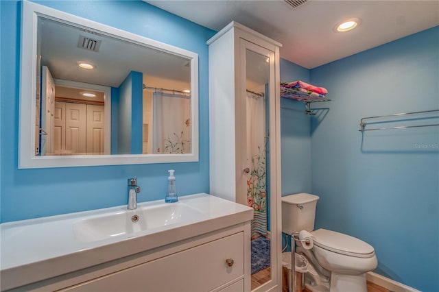 bathroom featuring walk in shower, hardwood / wood-style floors, vanity, and toilet