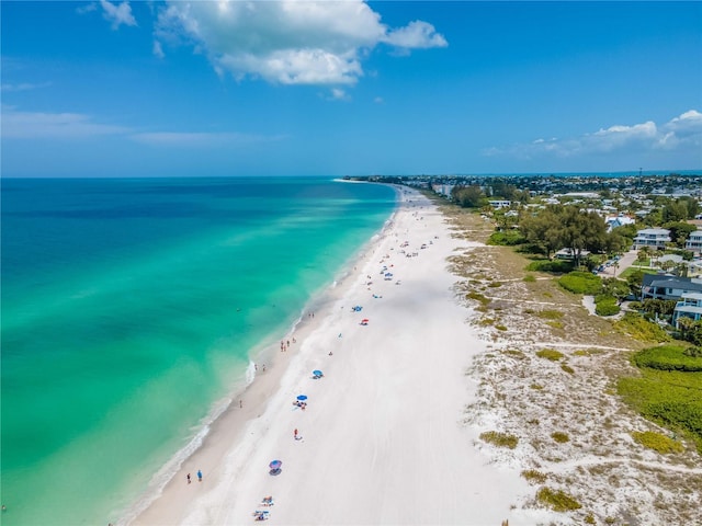 drone / aerial view with a water view and a beach view