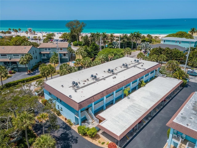 birds eye view of property with a water view and a beach view