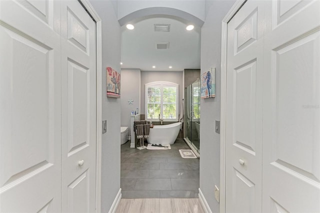 bathroom with a washtub and toilet