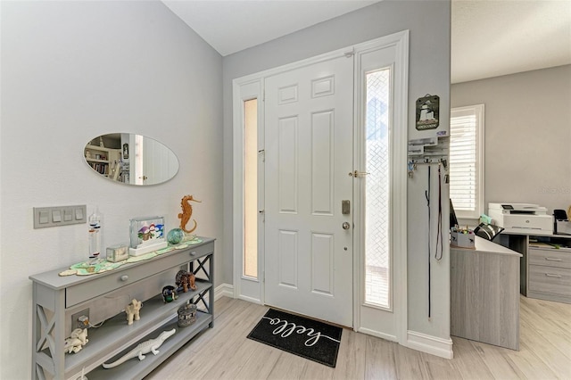 foyer with baseboards and light wood-style floors