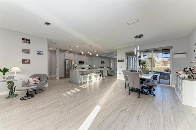 interior space with baseboards, visible vents, and light wood finished floors