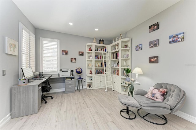 office space with baseboards, light wood-style floors, and recessed lighting