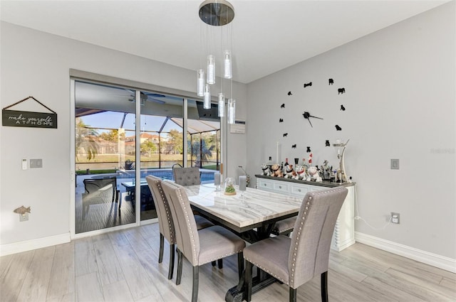 dining space featuring baseboards, light wood-style floors, and a ceiling fan