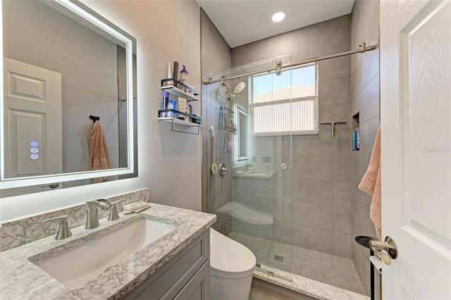 bathroom featuring a shower stall, toilet, and vanity
