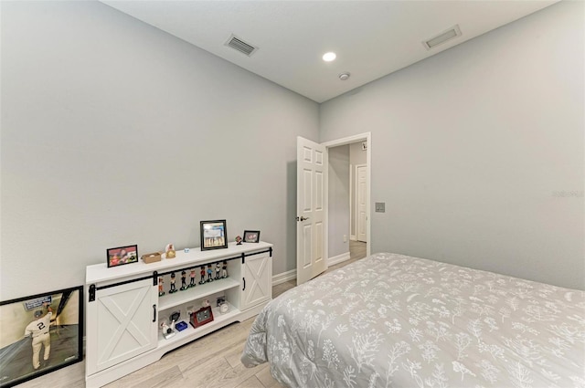 bedroom with baseboards, visible vents, and light wood-type flooring