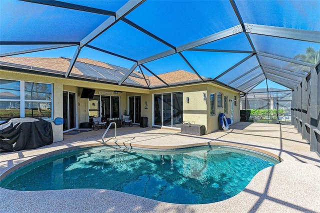 pool with glass enclosure and a patio area