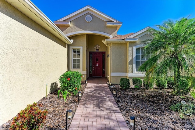 entrance to property featuring stucco siding