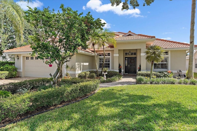 mediterranean / spanish house featuring a front lawn and a garage