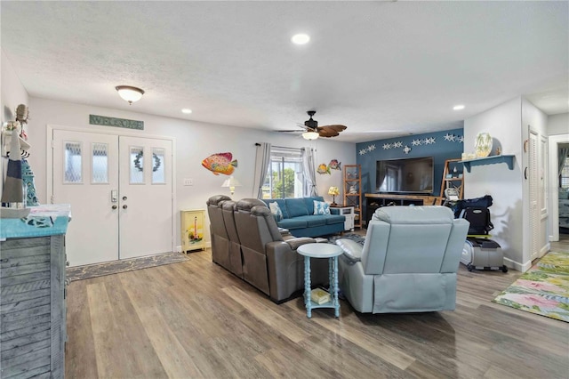 living room with wood-type flooring and ceiling fan