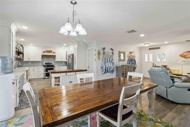 dining room featuring dark hardwood / wood-style flooring, a notable chandelier, and sink