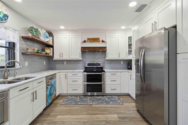 kitchen with white cabinetry, wood-type flooring, and appliances with stainless steel finishes