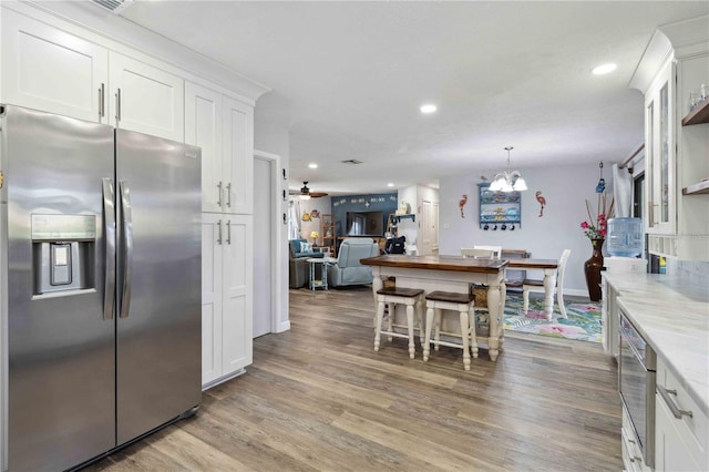 kitchen featuring white cabinets, stainless steel fridge with ice dispenser, and hardwood / wood-style floors