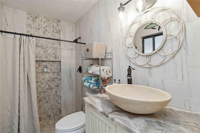 bathroom featuring vanity, a textured ceiling, toilet, and walk in shower