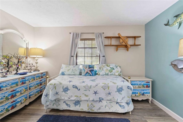 bedroom featuring a textured ceiling and dark hardwood / wood-style floors