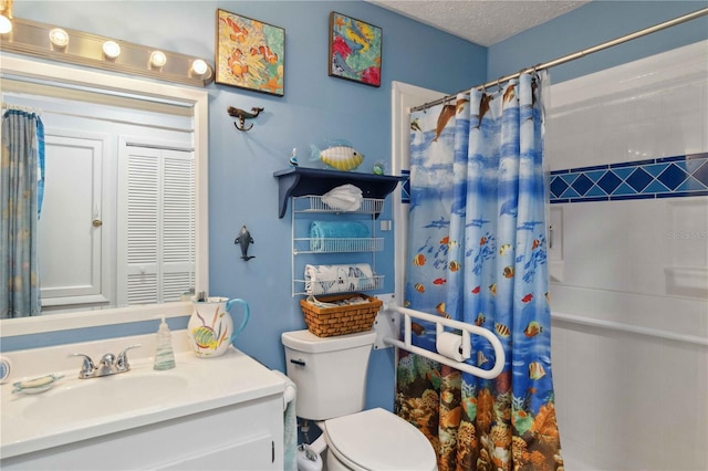 bathroom featuring toilet, vanity, a textured ceiling, and walk in shower