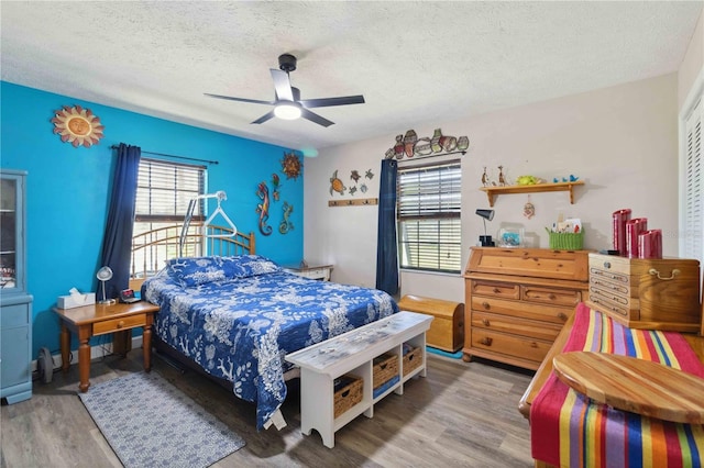 bedroom featuring hardwood / wood-style floors, ceiling fan, and a textured ceiling