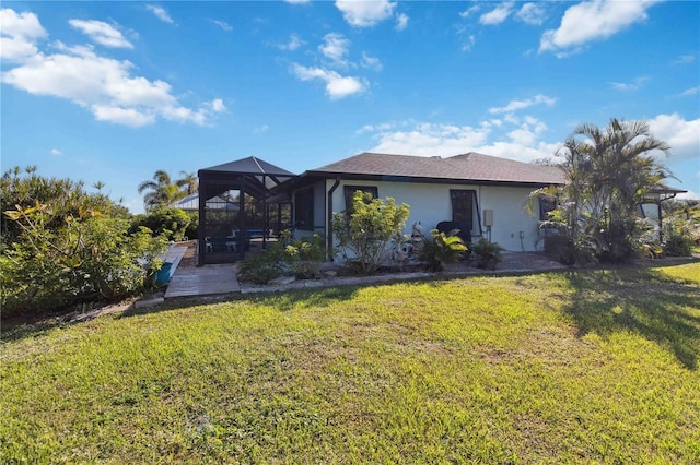 rear view of house featuring a lawn and a lanai