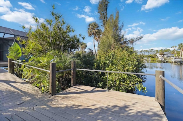 deck with a lanai, a water view, and a boat dock