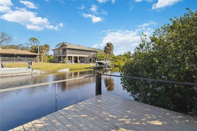 dock area with a lawn and a water view