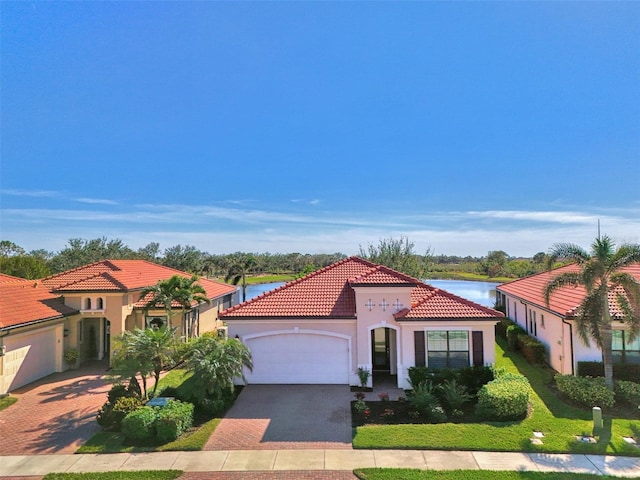 mediterranean / spanish-style house featuring a water view and a garage