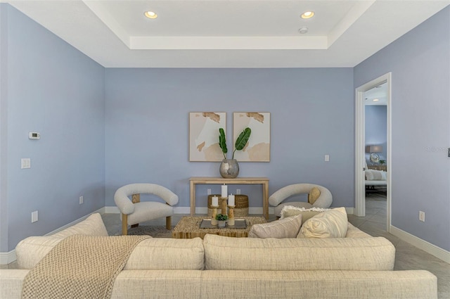 living room featuring carpet flooring and a raised ceiling