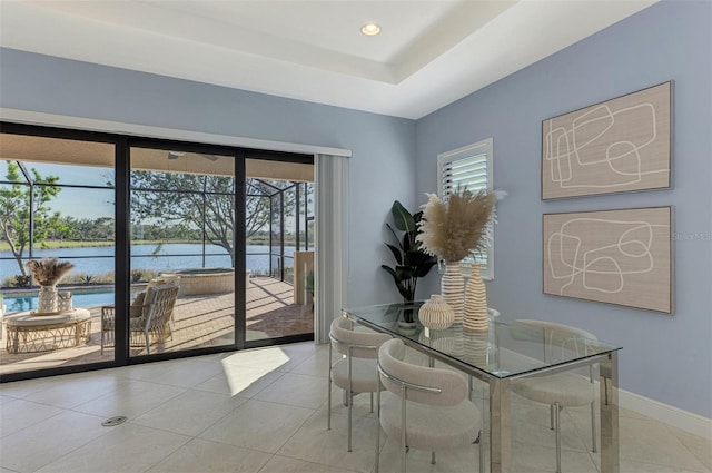 dining room featuring a water view and light tile patterned flooring