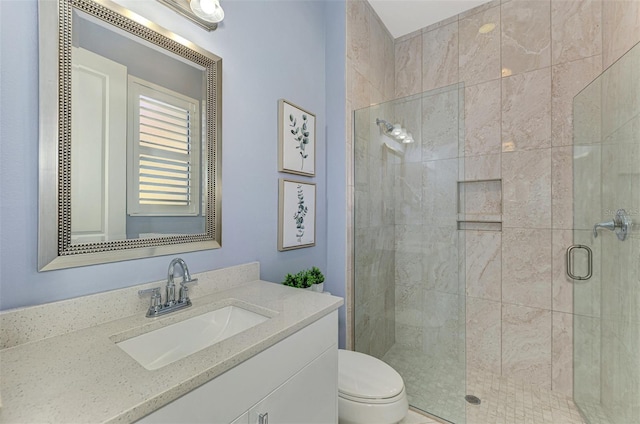 bathroom with vanity, toilet, and an enclosed shower