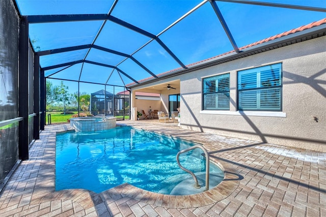 view of swimming pool with a lanai, an in ground hot tub, ceiling fan, and a patio