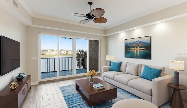 living room featuring light wood-type flooring, ceiling fan, and ornamental molding