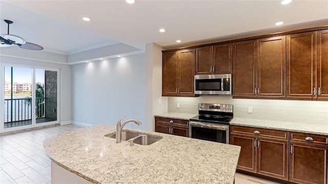 kitchen featuring sink, decorative backsplash, ornamental molding, an island with sink, and stainless steel appliances