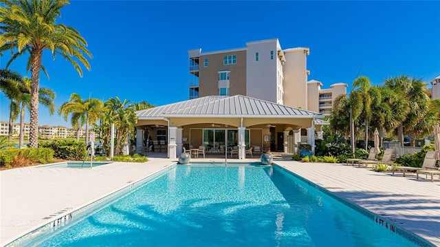 view of swimming pool featuring ceiling fan and a patio