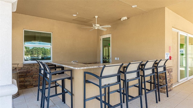 view of patio / terrace featuring ceiling fan and a bar