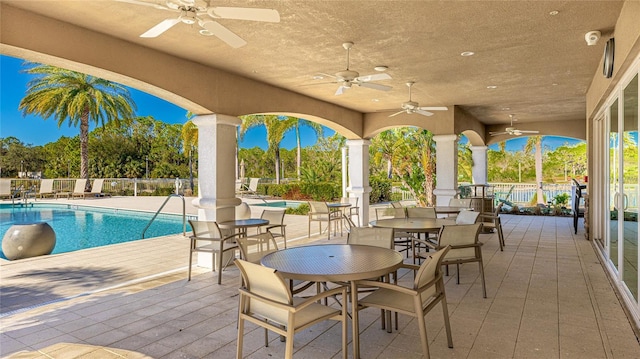 view of patio featuring ceiling fan and a community pool