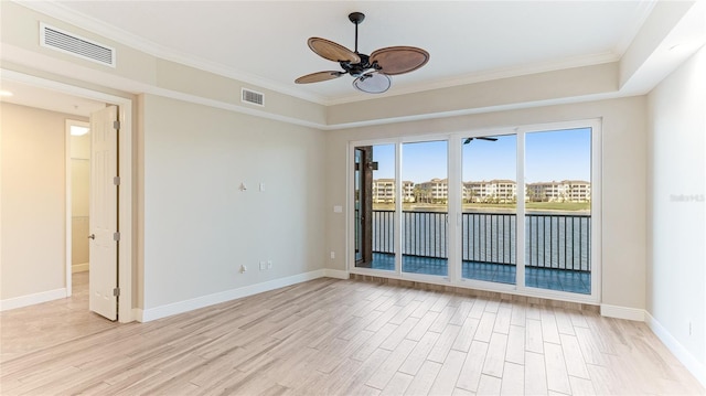spare room with ceiling fan, light wood-style floors, baseboards, and crown molding