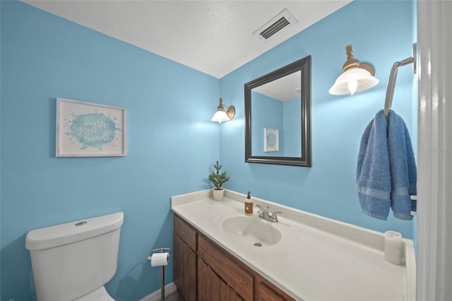 bathroom featuring vanity, a textured ceiling, and toilet