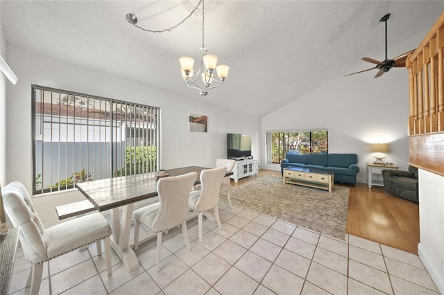 dining space featuring a textured ceiling, high vaulted ceiling, light hardwood / wood-style floors, and ceiling fan with notable chandelier