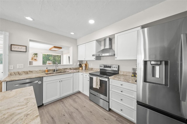 kitchen featuring wall chimney exhaust hood, sink, white cabinetry, and stainless steel appliances