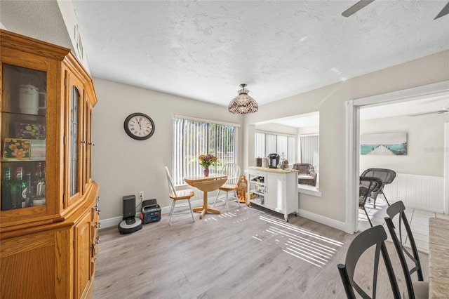 interior space with ceiling fan, light wood-type flooring, and a textured ceiling