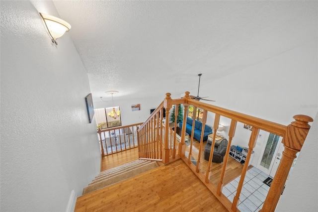 staircase featuring ceiling fan and wood-type flooring