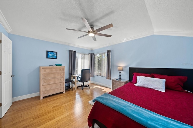 bedroom with hardwood / wood-style floors, a textured ceiling, ceiling fan, and ornamental molding