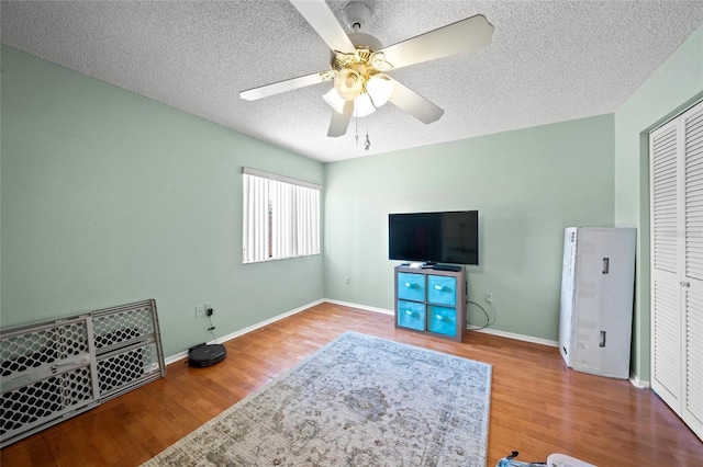 bedroom featuring ceiling fan, a textured ceiling, and hardwood / wood-style flooring