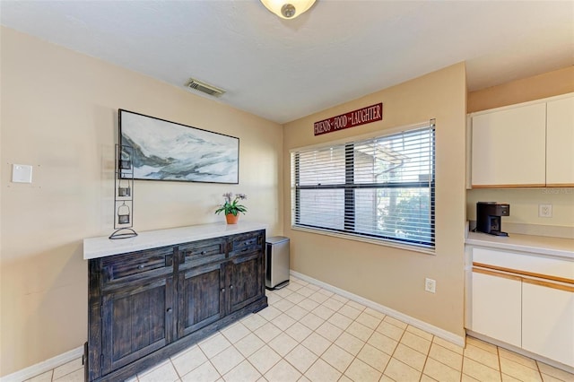 kitchen featuring light tile patterned floors and white cabinetry