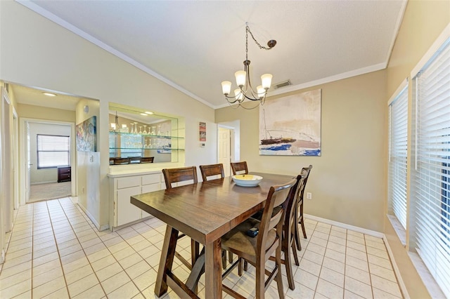 dining room with a chandelier, light tile patterned floors, ornamental molding, and vaulted ceiling