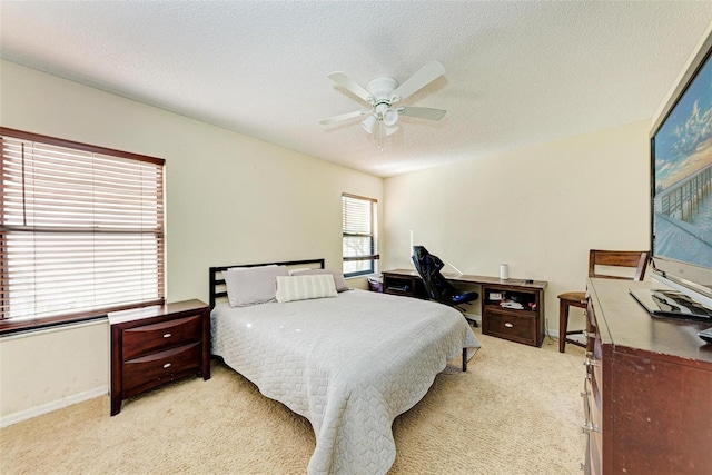 bedroom with light colored carpet, multiple windows, and ceiling fan