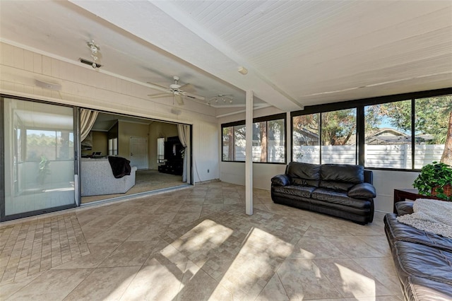 sunroom featuring beam ceiling and ceiling fan